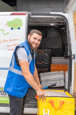 Un livreur récupère un colis prêt à être livré, illustrant l’efficacité du service de livraison