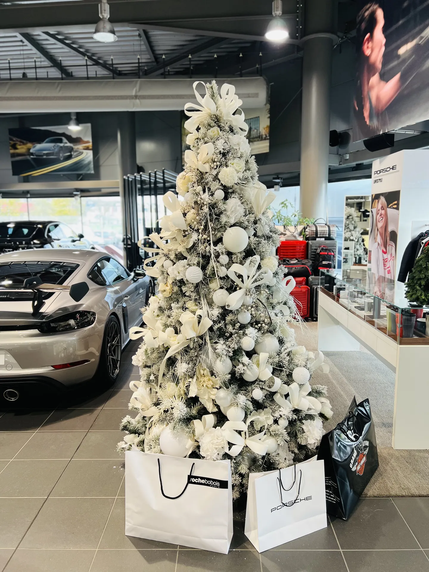Installation d'un sapin de Noël entièrement blanc avec fausse neige pour un showroom de voitures de luxe à Dardilly près de Lyon