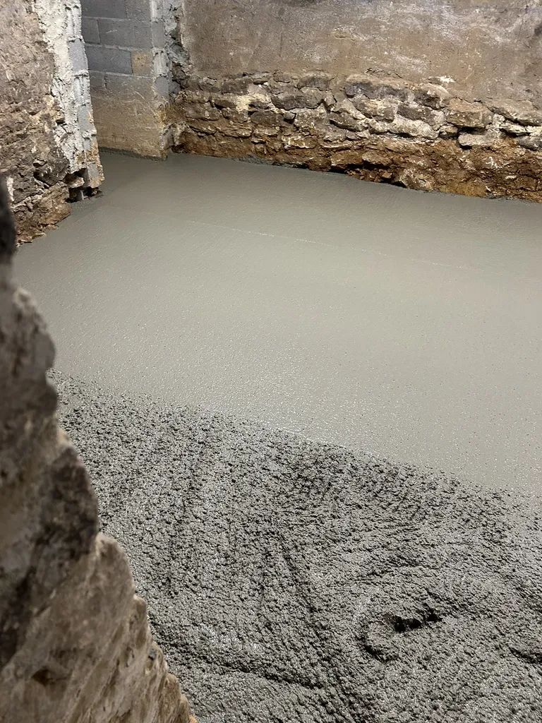 Travaux de décaissement du sol à l’aide d’un mini-engin afin de créer une pièce habitable lors d’une rénovation de maison à Anse (Rhône – 69