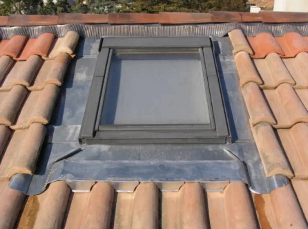 Pose de fenêtre de toit avec raccords étanches sur toiture tuiles pour un confort optimal