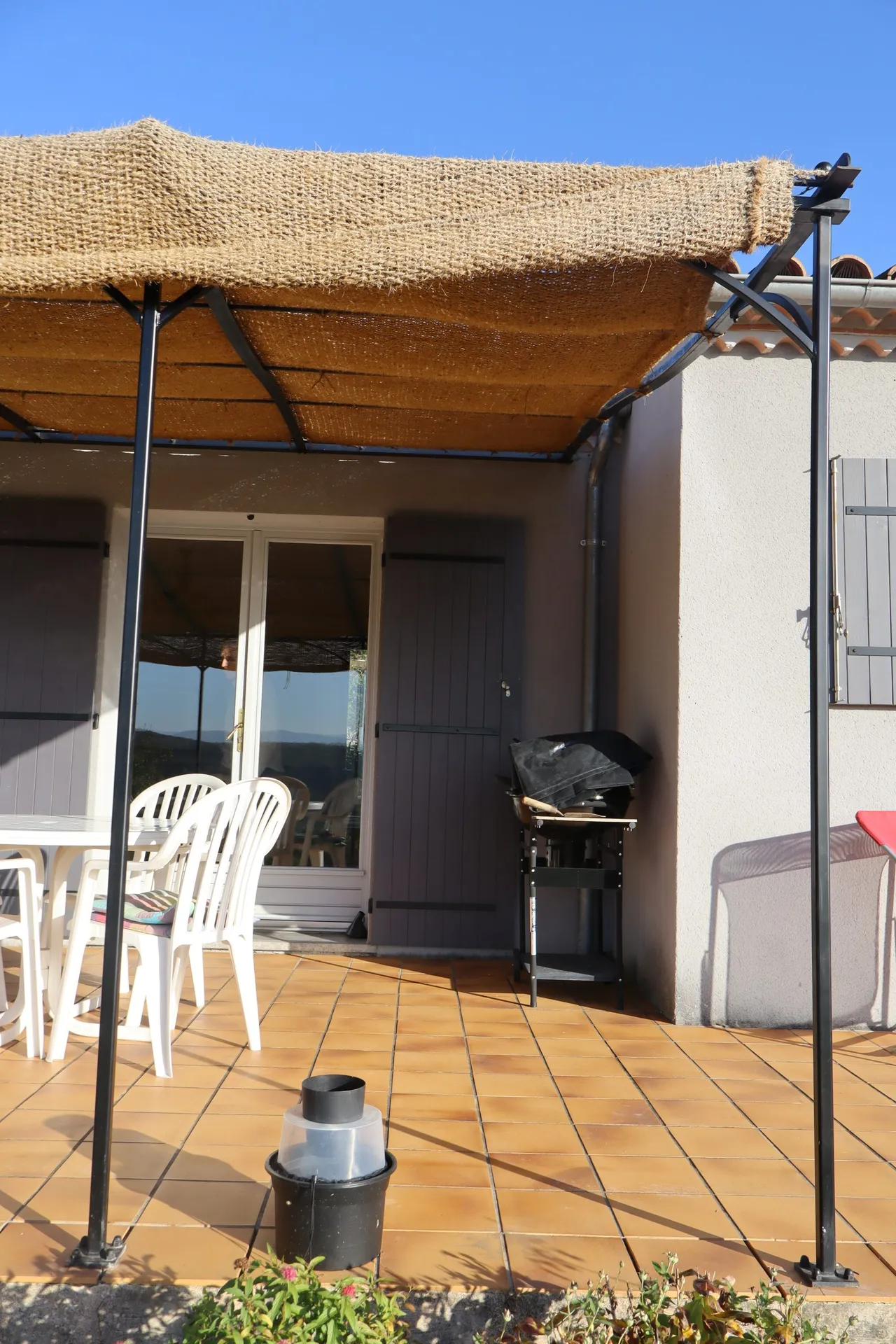 Pergola en fer forgé avec une toile de jute à Pradons en Ardèche pour l'été.