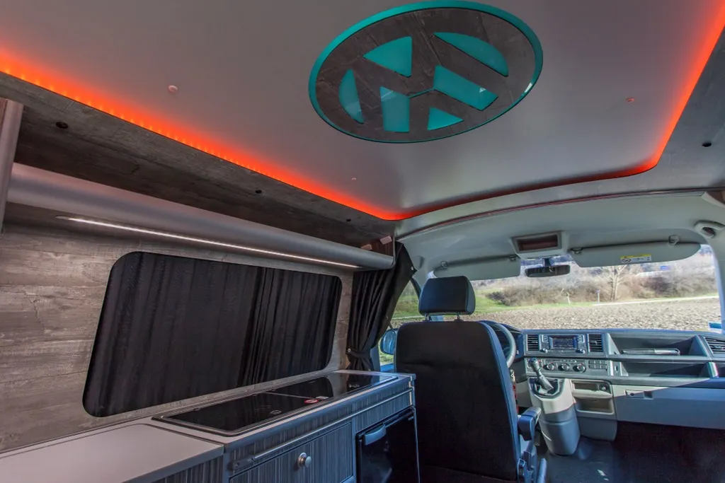 Aménagement intérieur sur-mesure VW Transporter T6 L1H1 avec plafonnier signature logo VW rétroéclairé à Paris et en Île-de-France