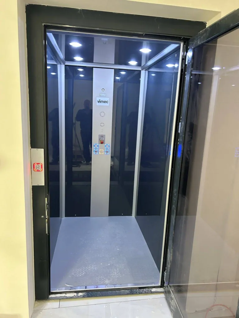 porte battante avec verre panoramique et passage libre de 900 mm pour cet élévateur vertical VIMEC installé dans une maison rénovée près de Marseille