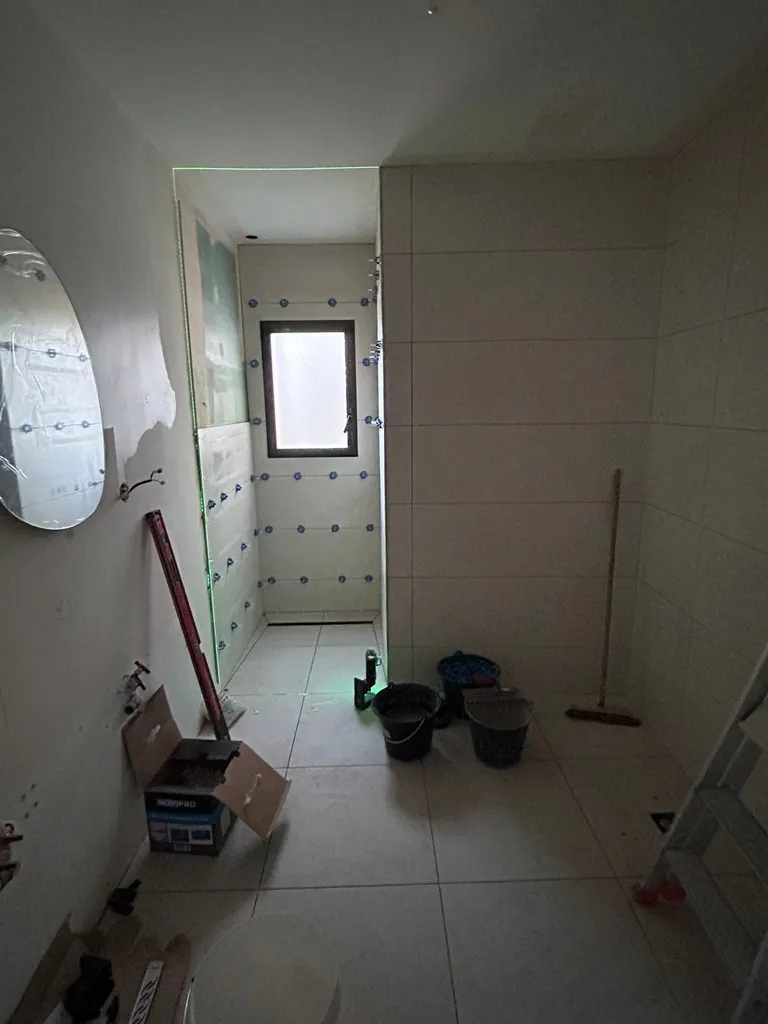 Encastrement et raccordement d'un caniveau de douche en inox pour garantir l'étanchéité parfaite d'une douche à l'italienne
