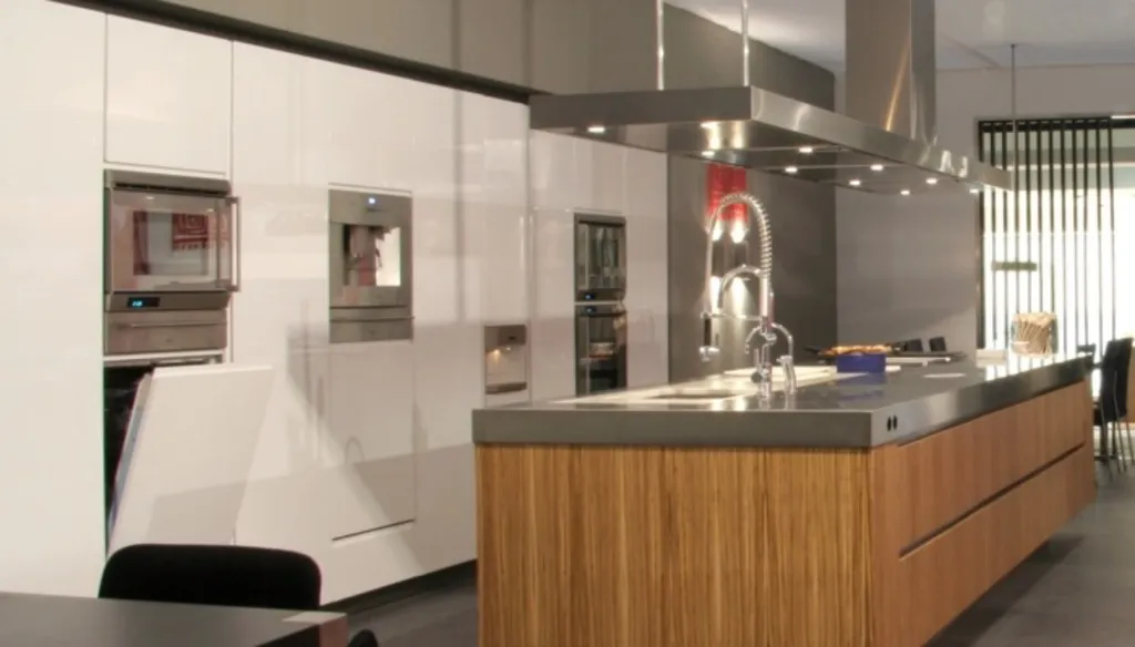 Îlot de cuisine en inox sur meuble en bois avec une hotte aspirante design Val-D’isère