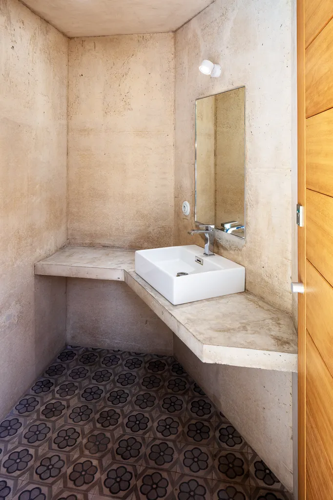 Salle d’eau minimaliste en béton avec vasque contemporaine et carreaux de ciment graphiques en Provence