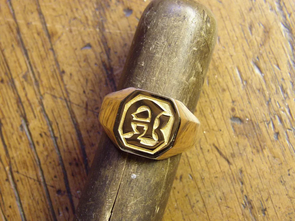 Chevalière en or jaune massif avec des lettres gravées dans le métal