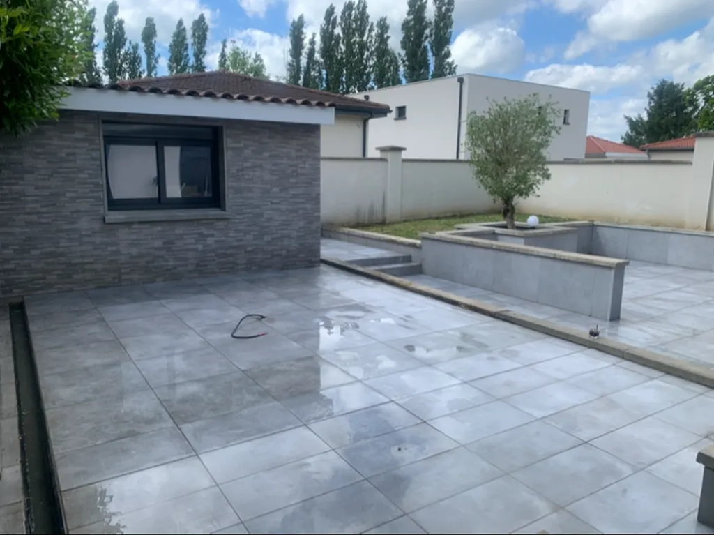 Aménagement de terrasse extérieure à Neuville-sur-Saône avec dalle béton, terrasse carrelée antidérapante et travaux de maçonnerie paysagère personnalisés