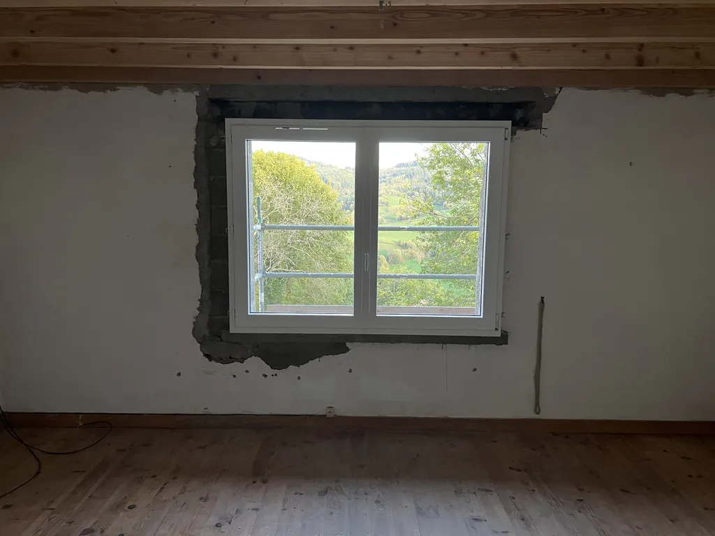 Fenêtre agrandie après pose vue extérieure dans une maison en pierre à Beaujeu (Rhône 69) améliorant la luminosité et le confort thermique