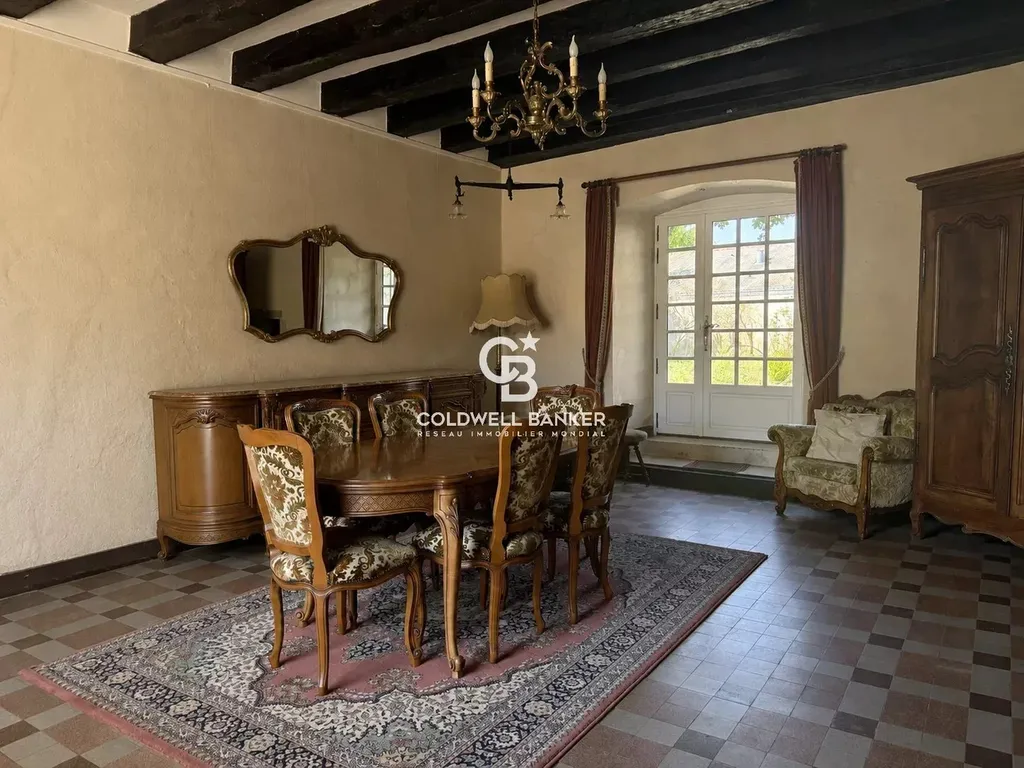 Salle à manger ouverte sur le parc de 2,4 hectares, dans ce prieuré du XIIe siècle au cœur d'un village sarthois.