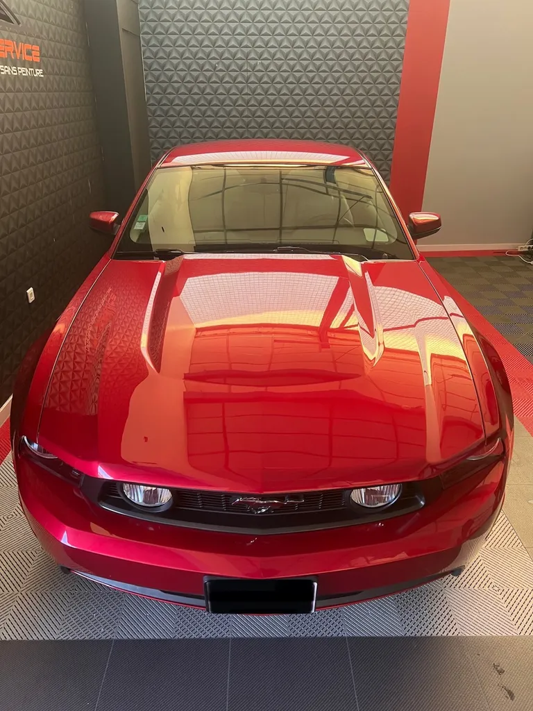 Pose d’un film de protection PPF Skyfol sur une Mustang V8 5.0 rouge, à Arnage