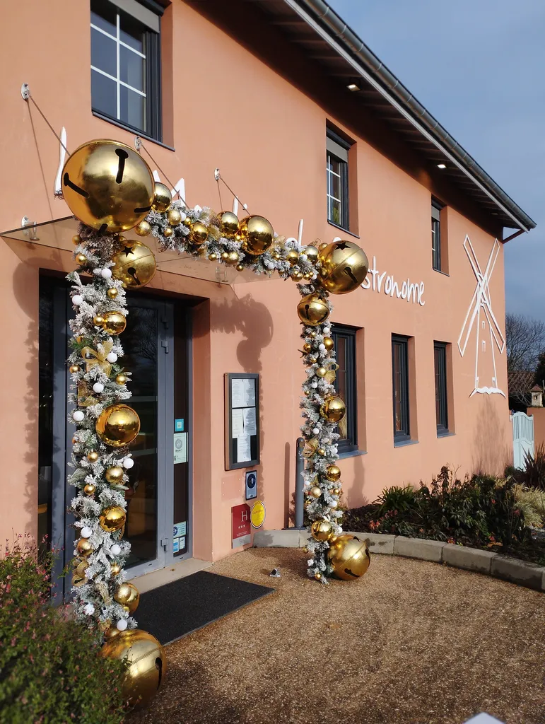 Décoration de Noël du restaurant « le Moulin du Gastronome » avec guirlandes artificielles garnies de boules or et blanches de différentes tailles et lumières scintillantes à Charnay-lès-Mâcon