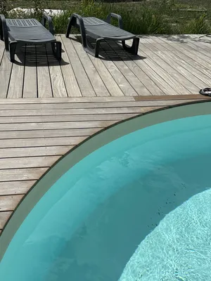 Rénovation des abords d’une piscine à Villemaréchal : terrasse bois, pierre du Sinaï et massifs paysagers