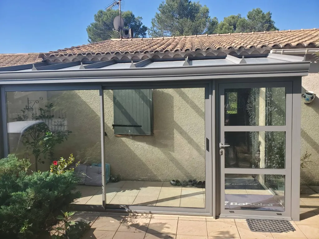 Installation d'une véranda en aluminium gris métal givrée près de Puyloubier