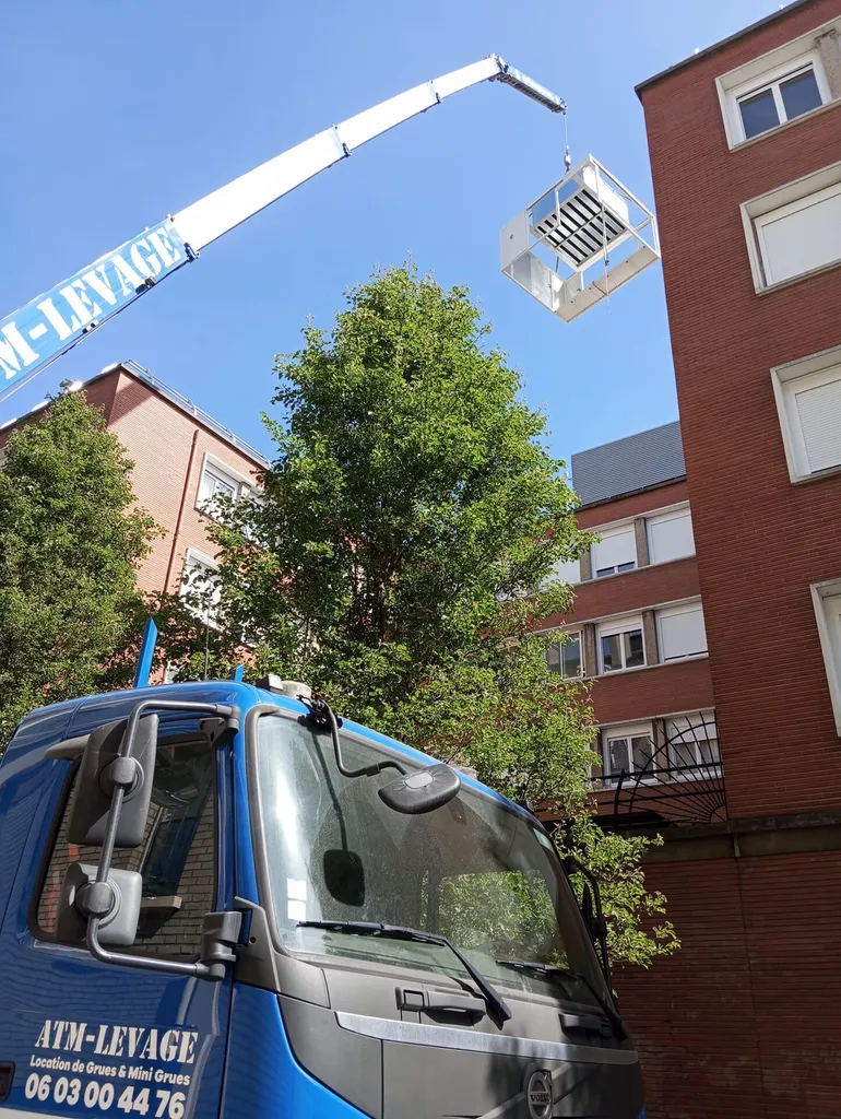 Location de grue sur remorque à Paris : pose d'un équipement technique en toiture