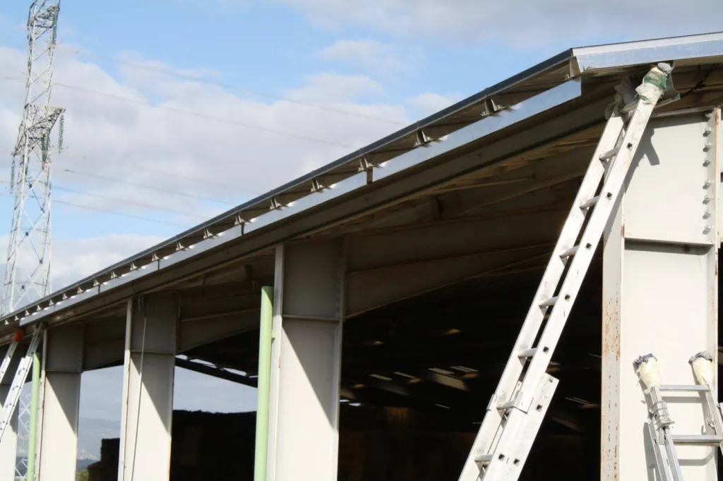 Fabrication et installation de gouttières aluminium G380 couleur gris métal sur un batiment industriel à Valence (Drôme)