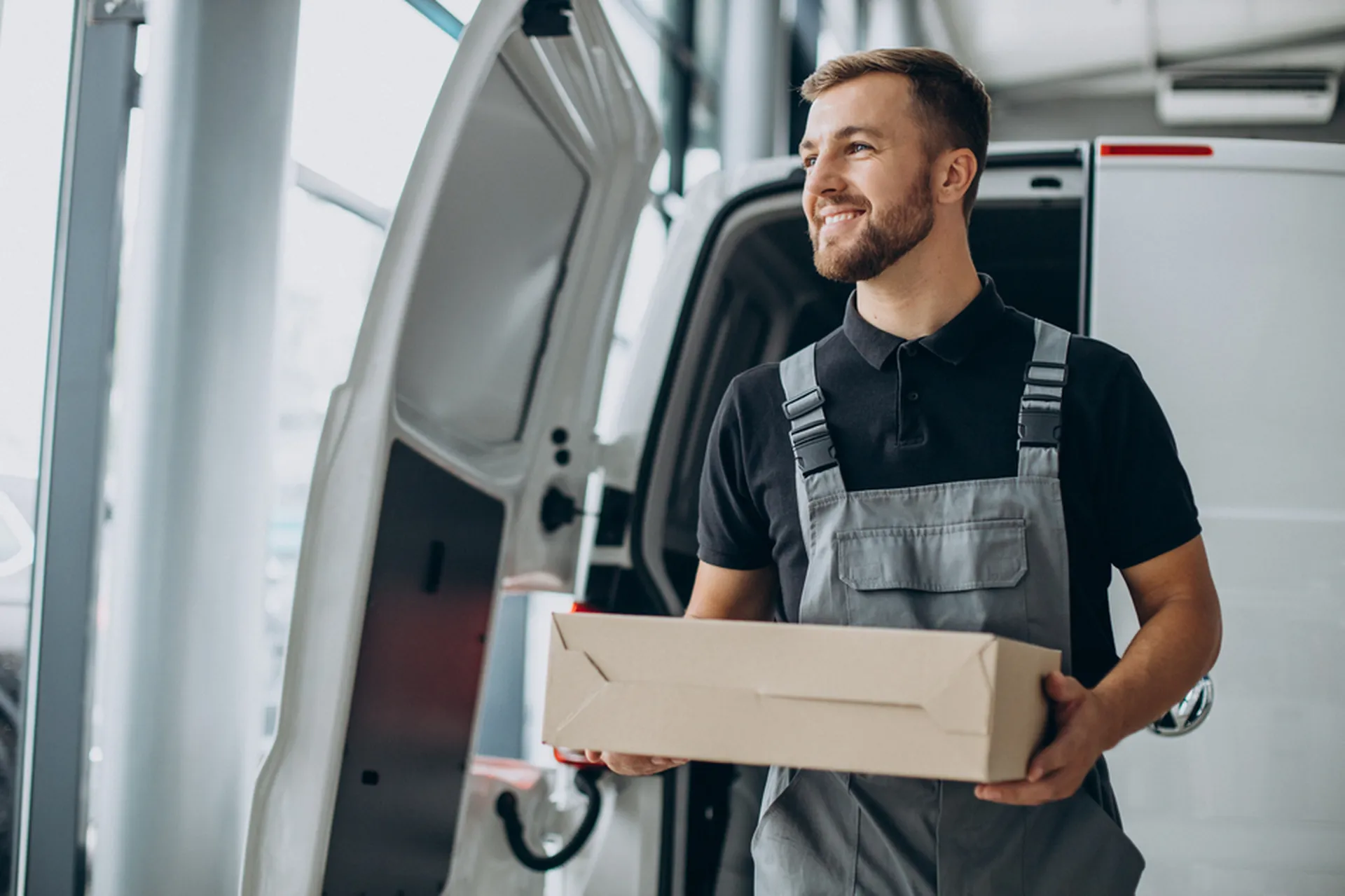 Chauffeur-livreur en interaction avec un client, illustrant les compétences de service, de rigueur et de professionnalisme attendues.