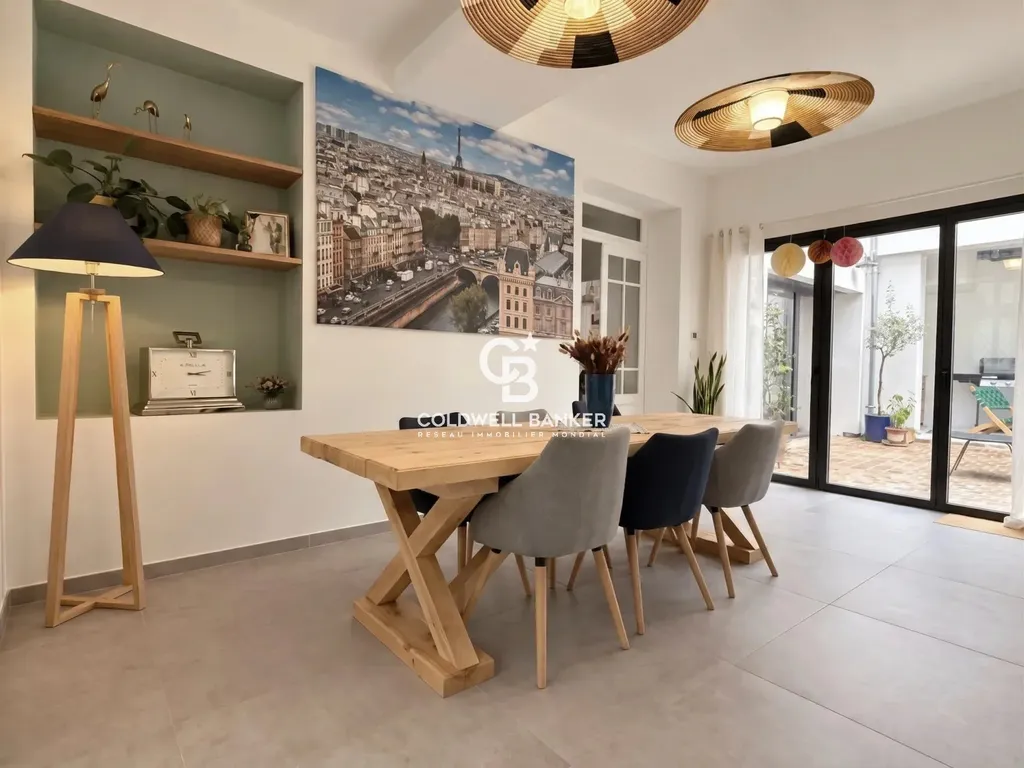 Salle à manger ouverte sur le patio par une grande baie vitrée