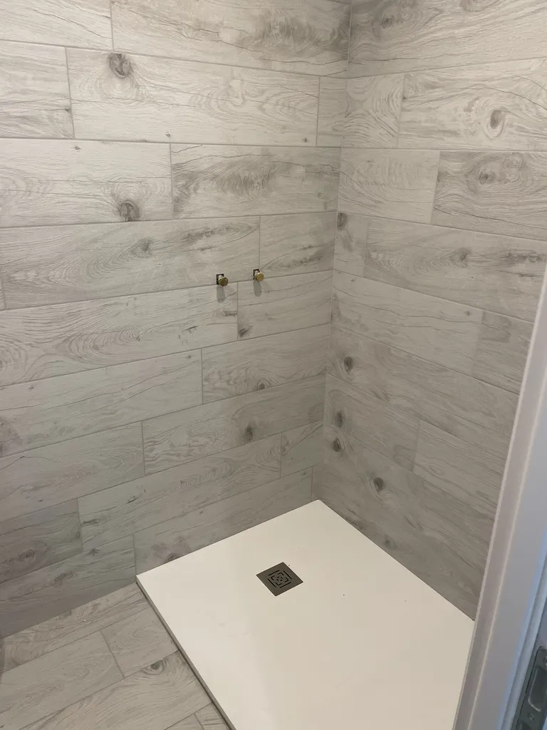 Mise en place et calage du receveur de douche extra-plat (140x90 cm) sur ses pieds réglables haute résistance.