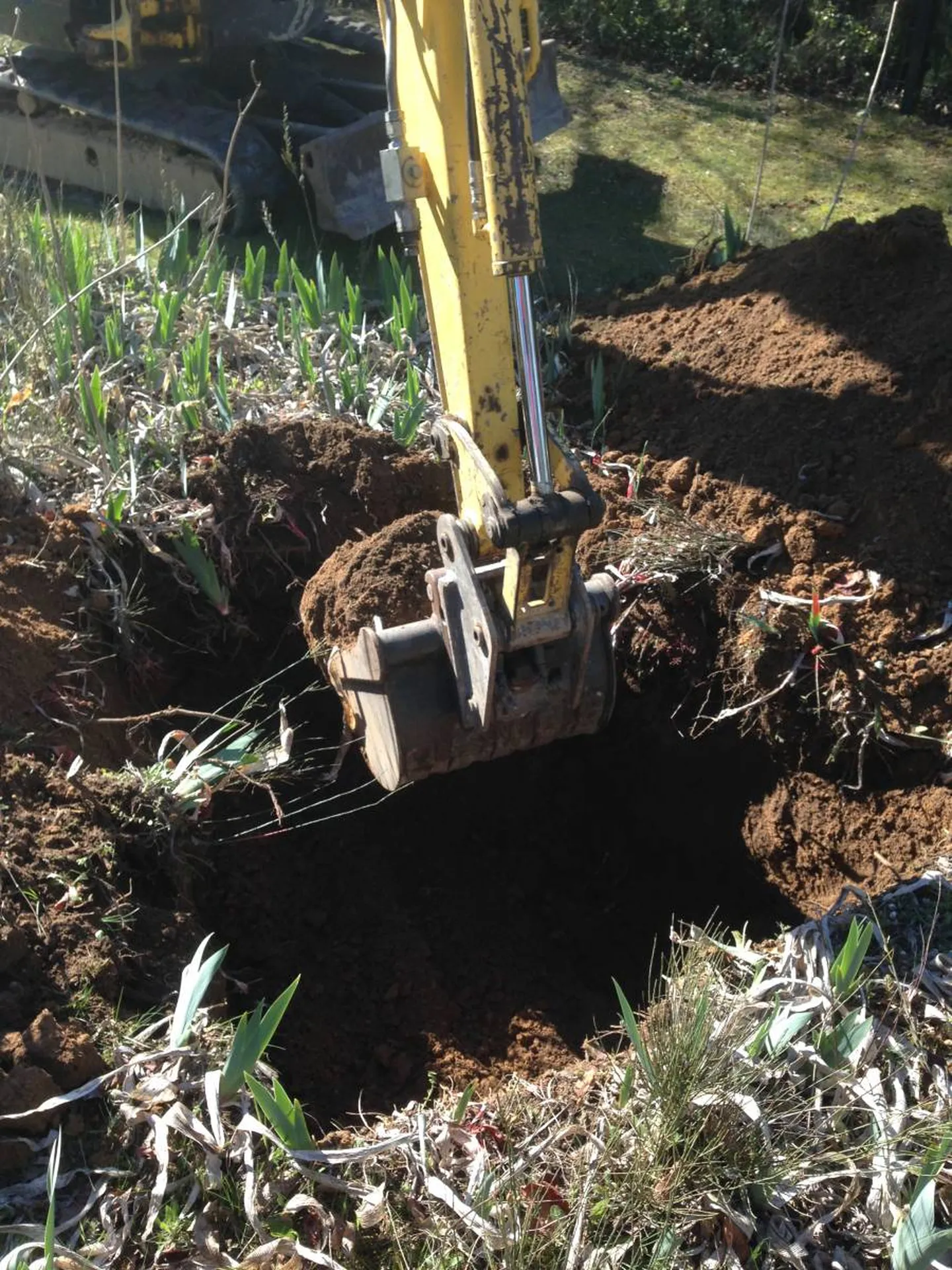 Réalisation d'un trou avec une mini pelle dans un jardin 