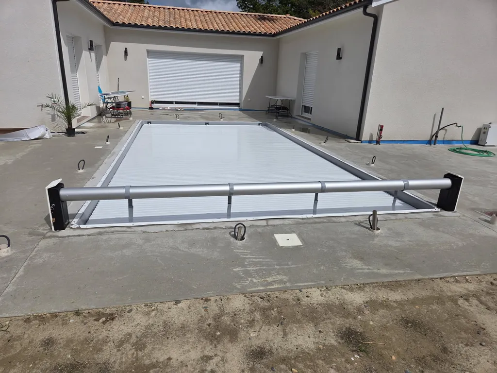 pisciniste sérieux pour installation d'une bâche de protection de piscine avec enrouleur à côté de Lacanau