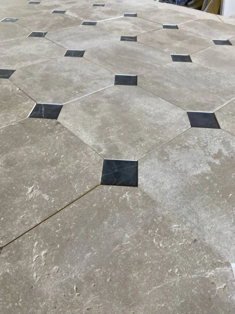Dallage en pierre naturelle clair vieilli avec cabochon noir