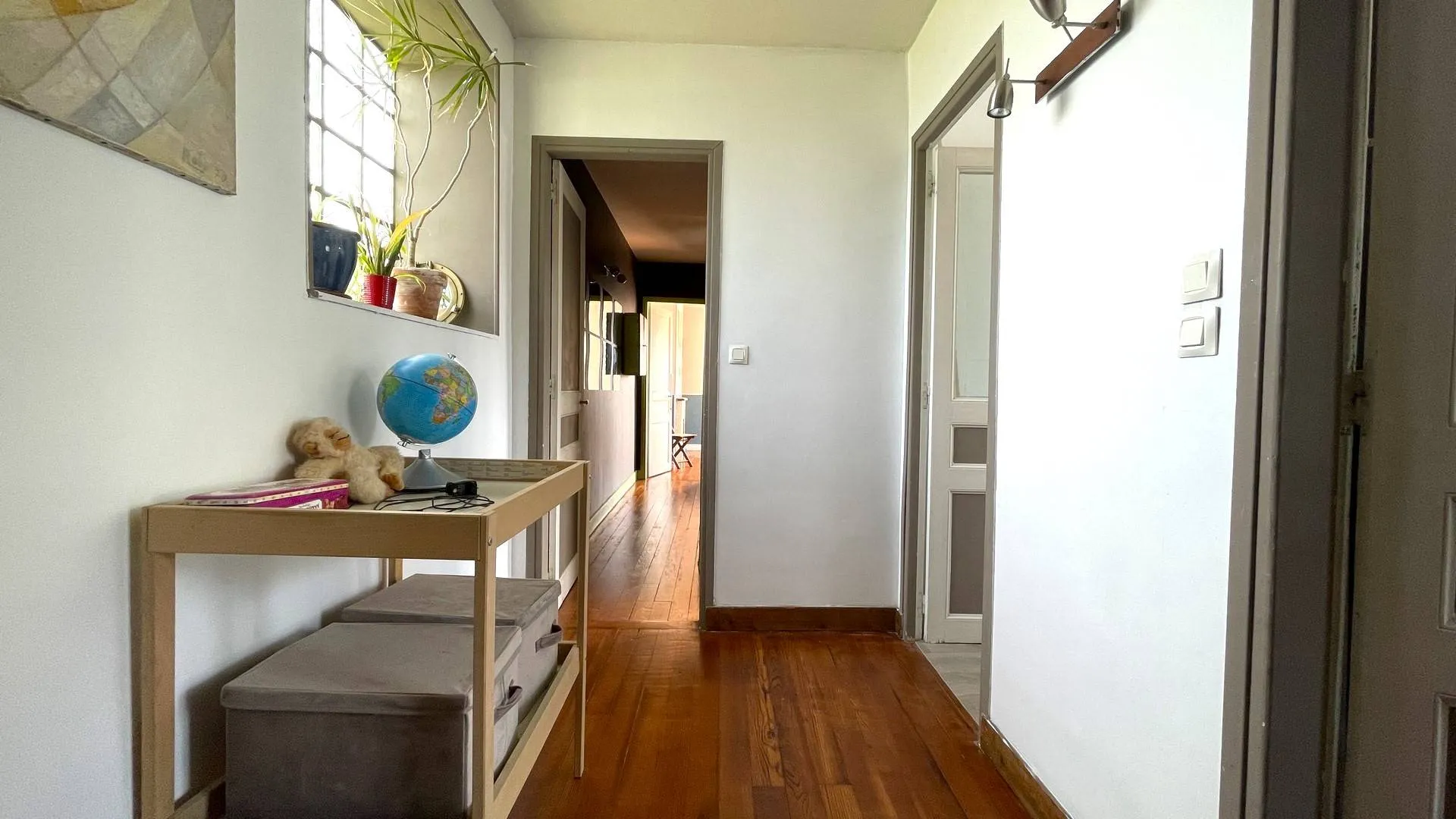 Maison à vendre avec buanderie et chambres** : Un palier desservant une buanderie et deux chambres, dont une avec accès à un balcon, au premier étage.