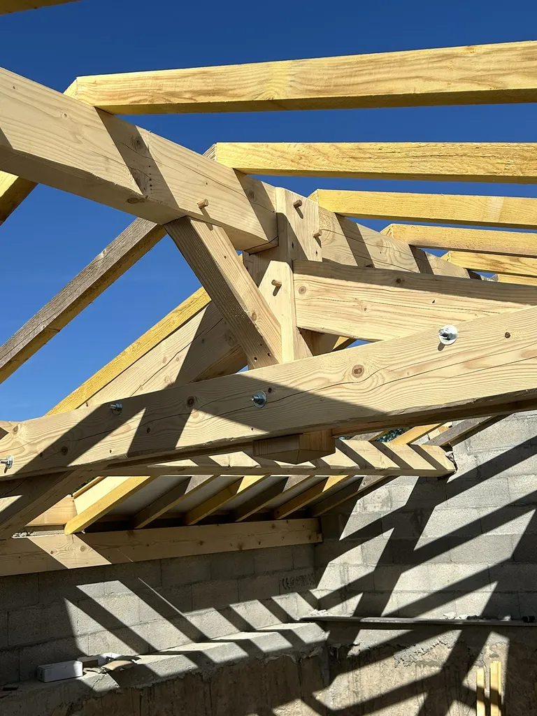 Réalisation de la charpente bois avec pannes, fermes et chevrons pour la toiture