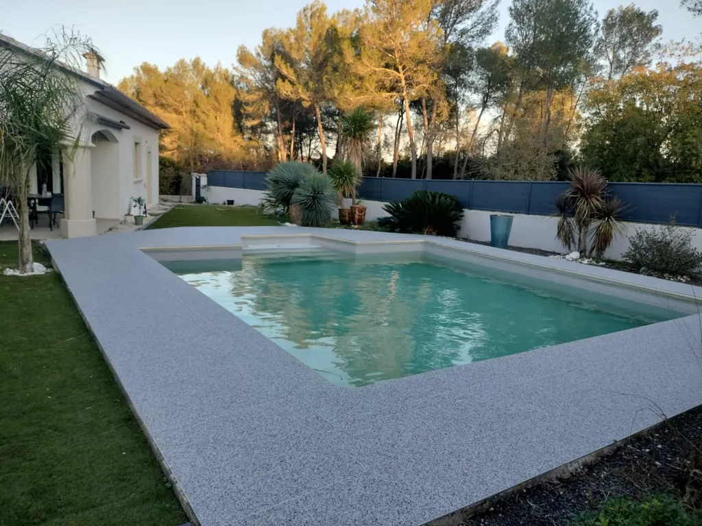 Pose de moquette de pierre bicolore avec finitions aluminium et préparation complète sur dalle existante à Assas