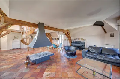 Vue salon lumière omniprésente cheminée centrale en vente chez Helix immobilier en exclusivité