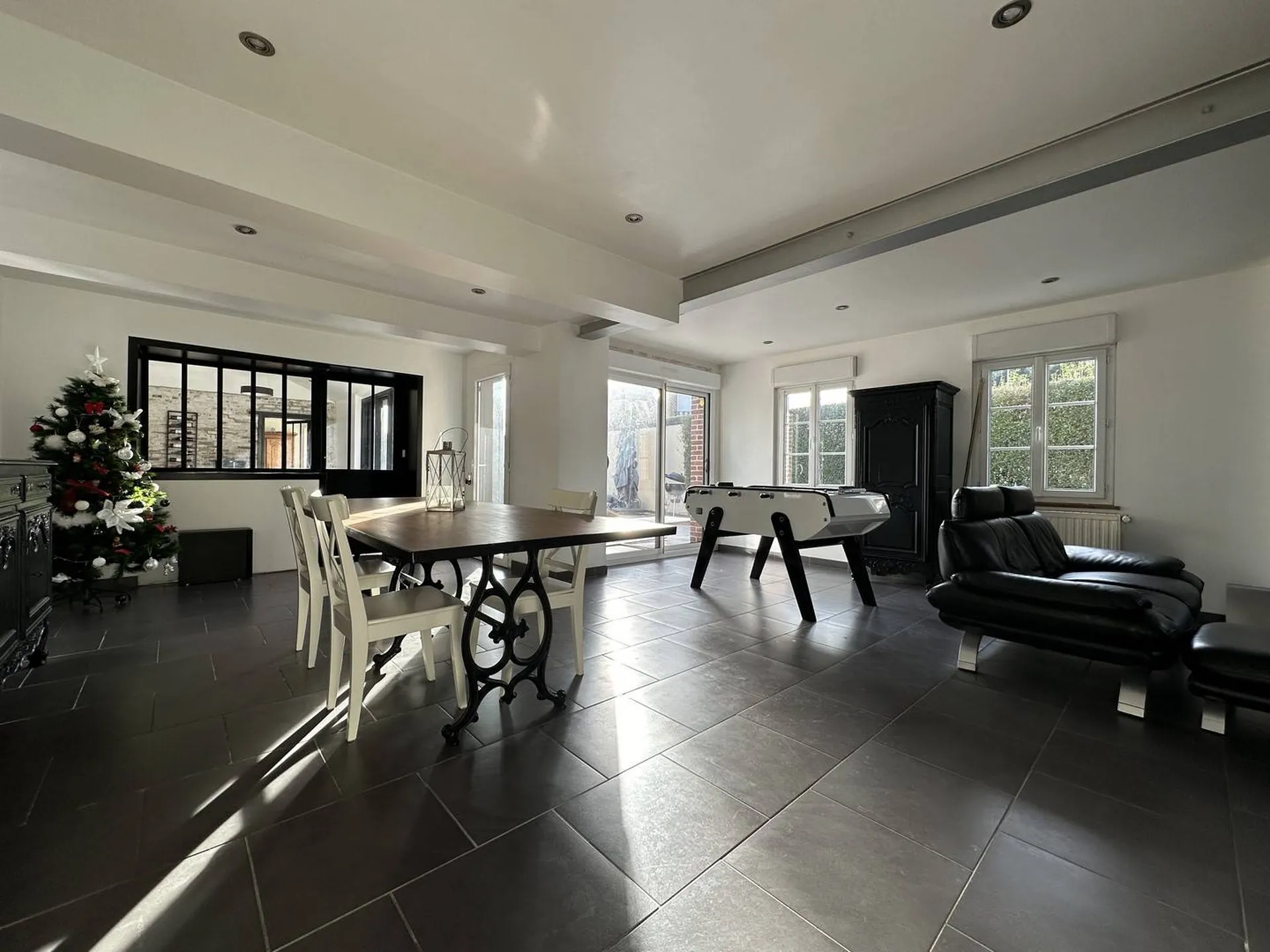 **Demeure avec cuisine lumineuse à vendre** : Rez-de-chaussée avec salon, salle à manger et cuisine équipée, donnant sur le jardin et la terrasse exposée plein sud, offrant un espace de vie convivial.