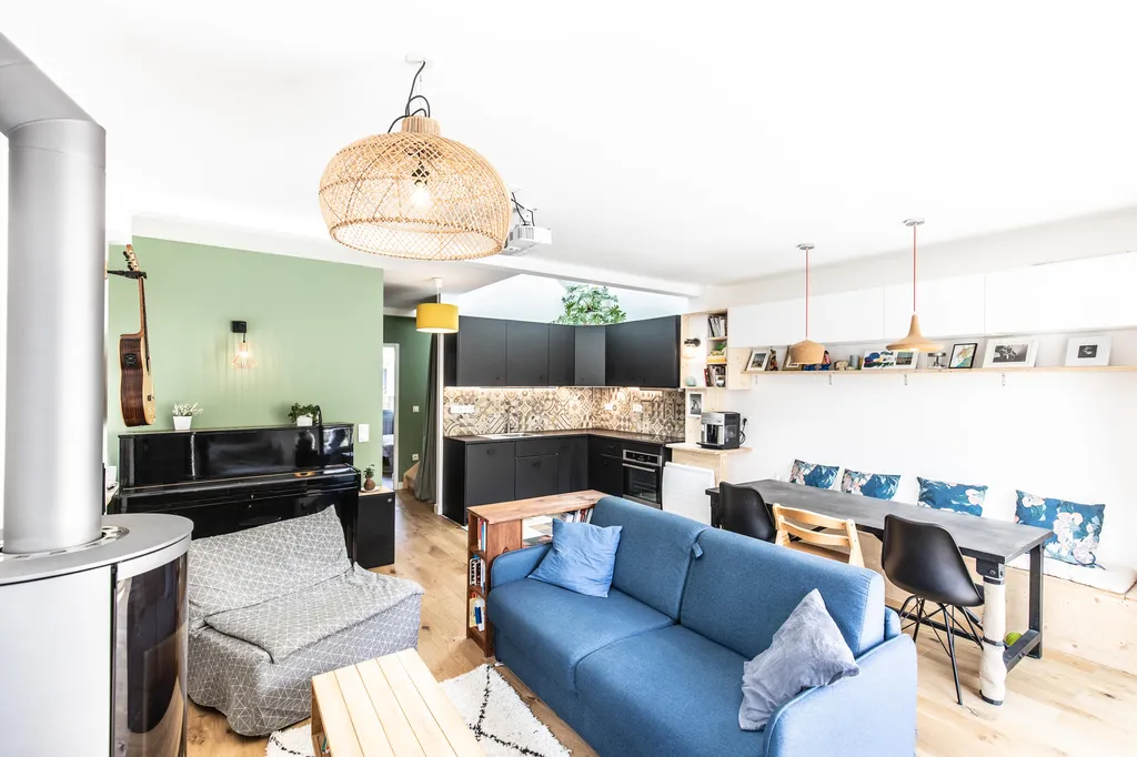 Pièce de vie traversante et lumineuse  AKIKO ARCHITECTURE – Bègles – Transformation du rez-de-chaussée Le séjour ouvert combine salon, salle à manger et espace de jeux en un lieu fluide et baigné de lumière. Suspensions naturelles, matières douces et mobi