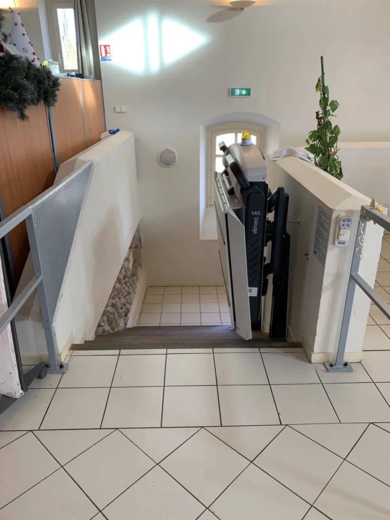Accueil facilité de la plateforme oblique VIMEC V65 dans un escalier courbe au sein d'un ERP près d'Aix en Provence