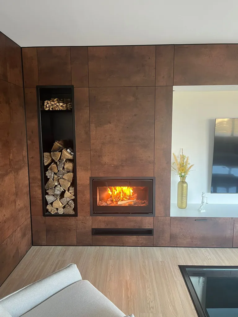 Insert SCAN 1006 au format panoramique pouvant accueillir de grandes bûches de 65 cm avec une niche à bois acier noir dans un ensemble de parement corten et une niche accueillant la TV