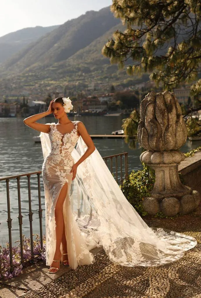 Robe de mariée sirène en dentelle. Décolleté plongeant en forme de v brodé de dentelle florale sur un fond nude.