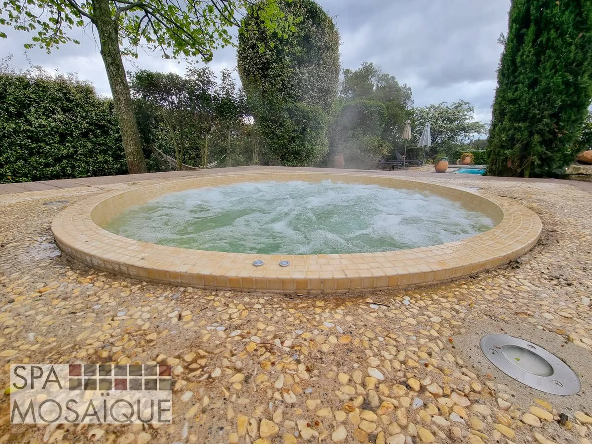Un spa mosaïque carrelé encastré dans une terrasse en béton à Aix-en-Provence