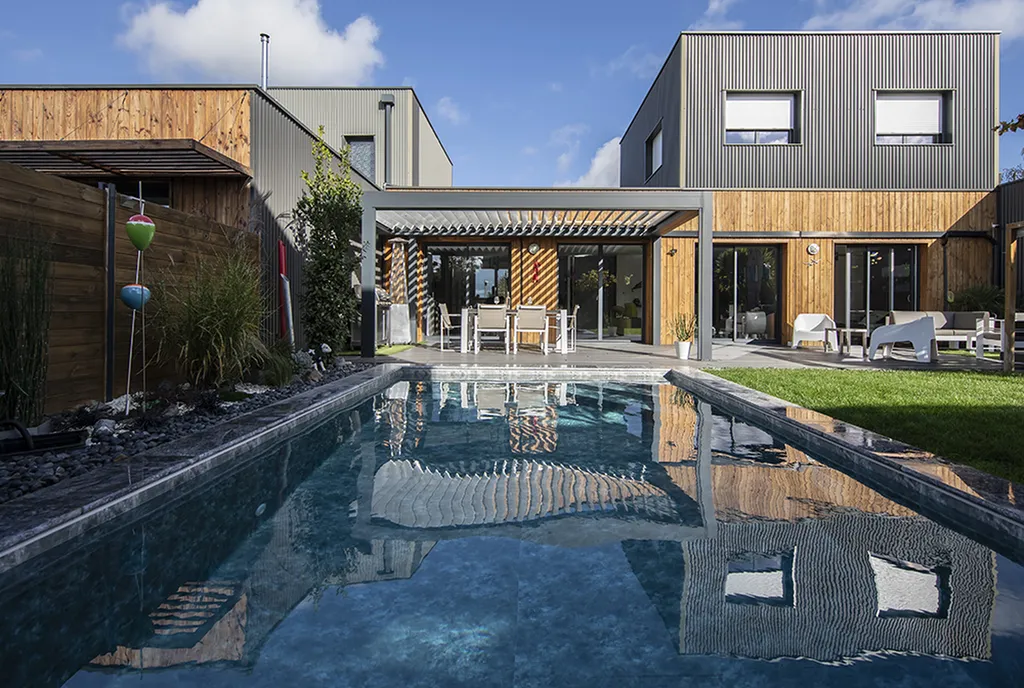 Pergola bioclimatique en aluminium anthracite adossée à une maison contemporaine à bardage bois avec piscine à Toulon et au Pradet