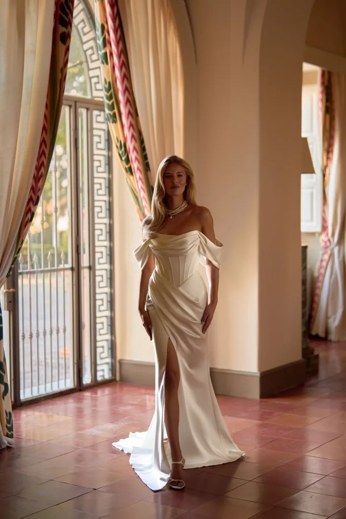 Robe de mariée sirène chic en satin mikado , drapée, bustier avec des manchons sur le haut des bras et fente sur la jambe modèle OSMANA de la créatrice ukrainienne Anna Sposa à Marseille