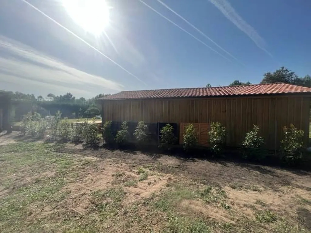Transformation par un professionnel d'un jardin à l’aide d’une haie de Photinias esthétique et fonctionnel aux alentours de Mézos