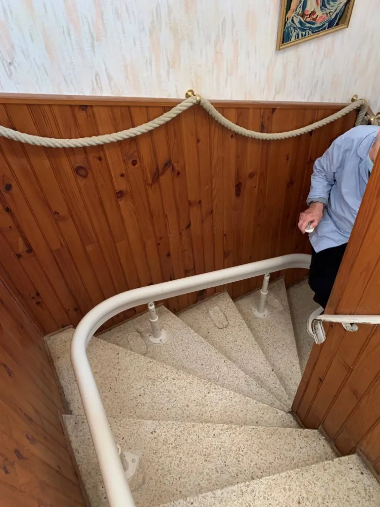 Encombrement minimal du rail dans l'escalier pour ce fauteuil monte escalier OTOLIFT Modul'Air intérieur dans escalier tournant à Martigues près d'Aix en Provence