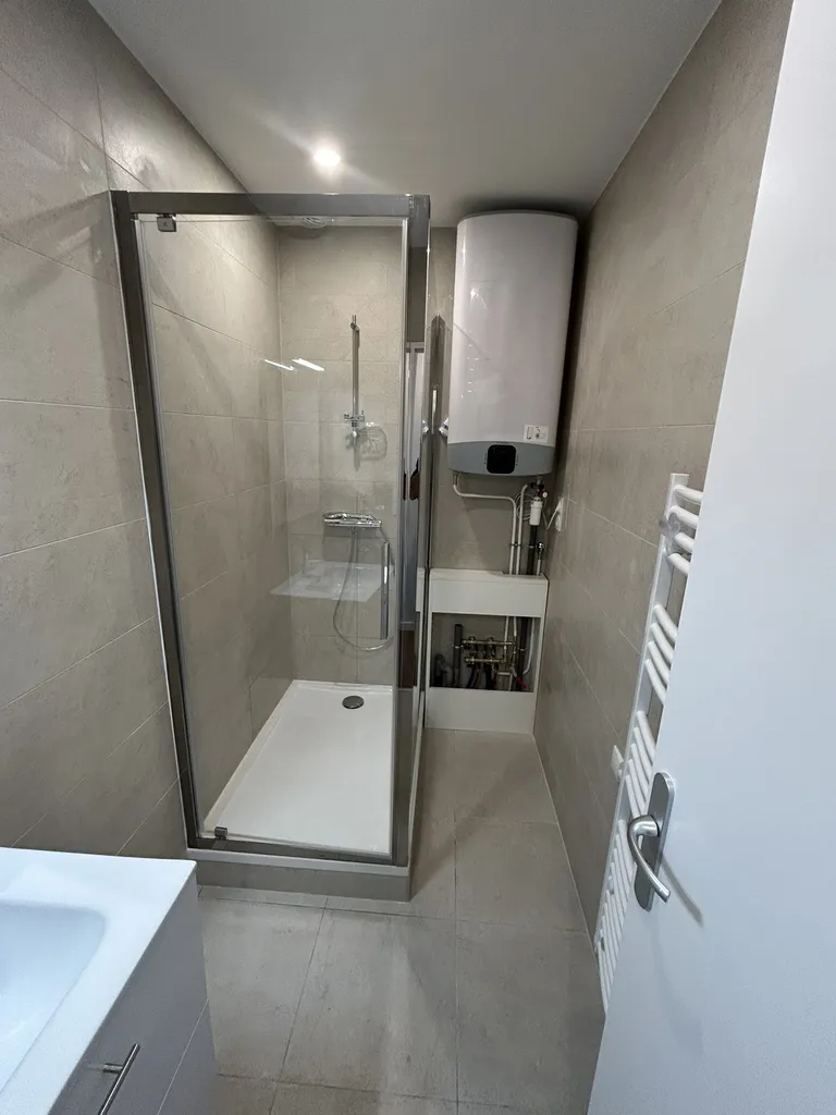 Salle de bain rénovée avec équipements modernes et finitions soignées