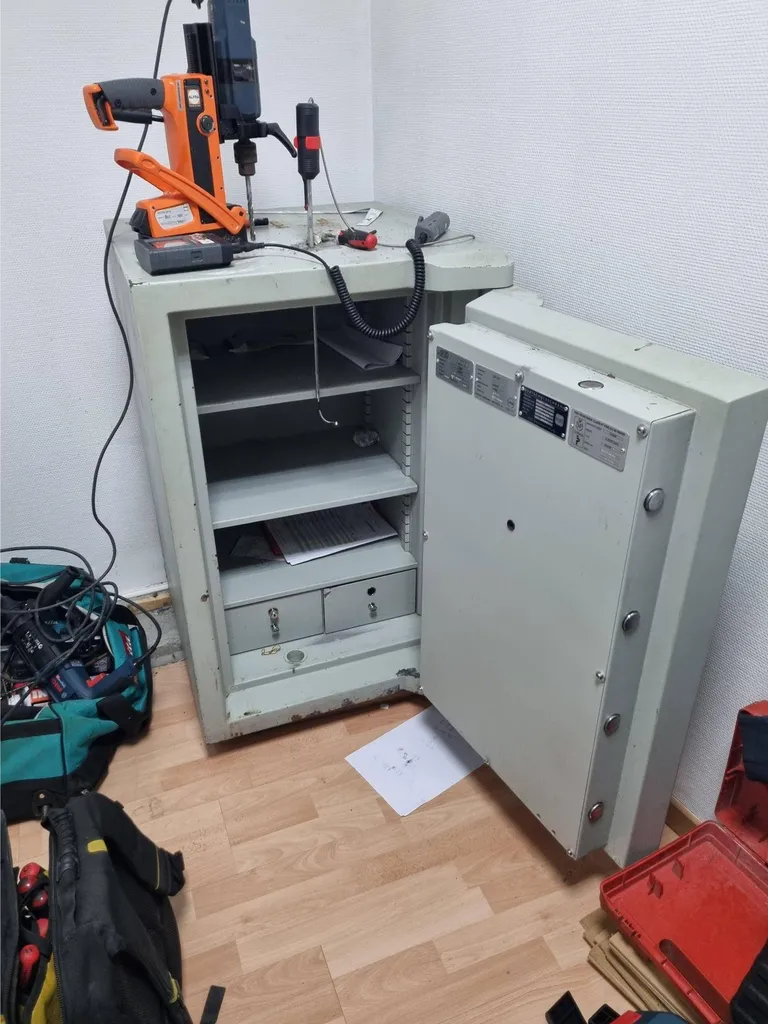 Technicien spécialisé ouvrant un coffre-fort avec outils professionnels pour dépannage