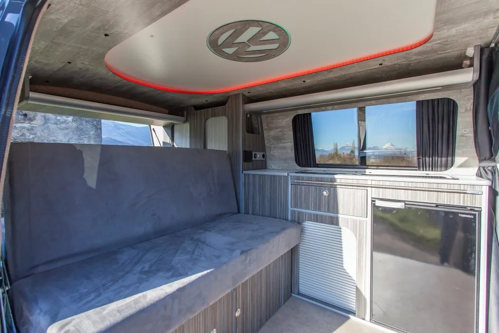Aménagement intérieur sur-mesure VW Transporter T6 L1H1 avec plafonnier signature logo VW rétroéclairé à Paris et en Île-de-France