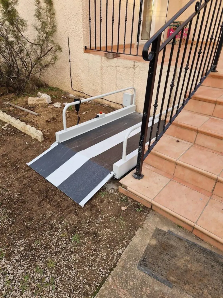 le volet articulé facilite le transfert du fauteuil roulant sur la plateforme de ce mini élévateur LEHNER Liftboy à Marignane près de Marseille