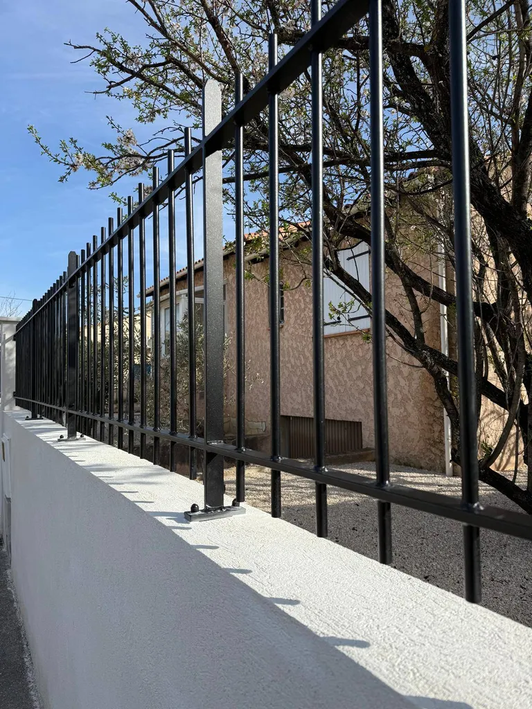 Clôture en acier robuste et élégante par l'Atelier du Ferronnier, protégeant une résidence à Calas Cabriès.