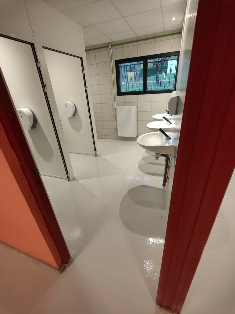 Application de résine polyuréthane grise 7035 avec finition pommelée pour les sols d'une salle des fêtes à Miserey-Salines