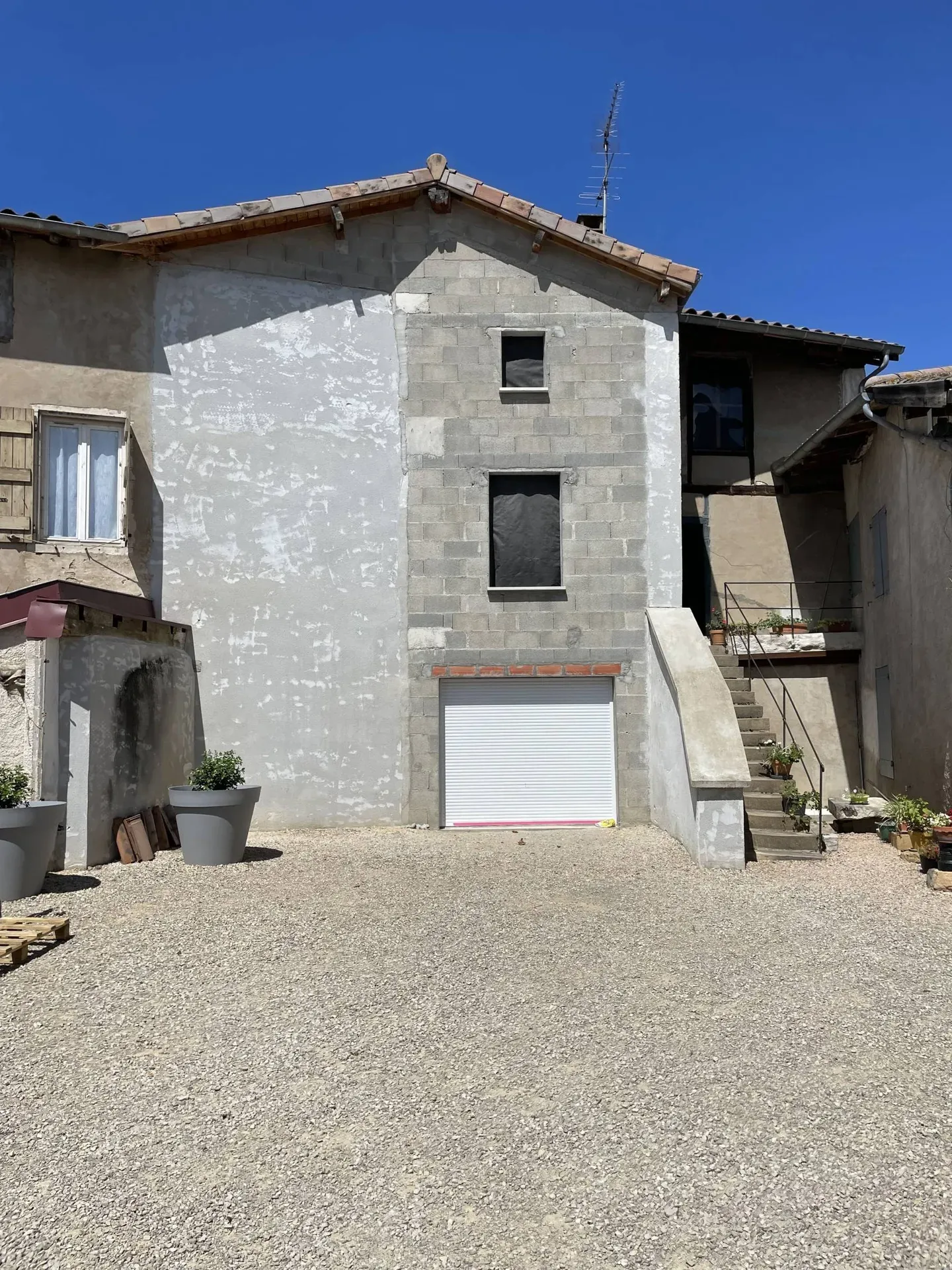 Installation de la baie vitrée avec volet roulant et des deux fenêtres aux étages après création des ouvertures dans le mur porteur à Montmerle-sur-Saône