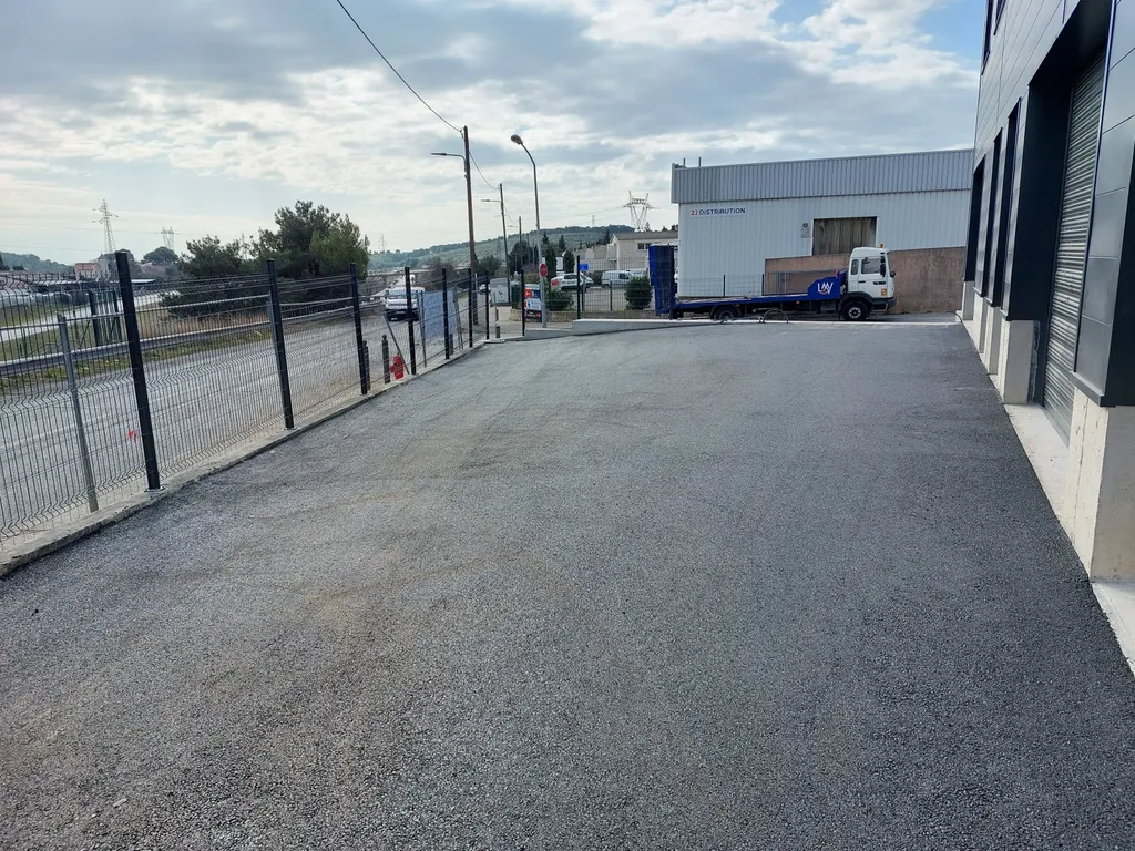 Réalisation du parking d'un entrepôt en enrobé de bitume noir à Septême les Vallons dans les Bouches du Rhône