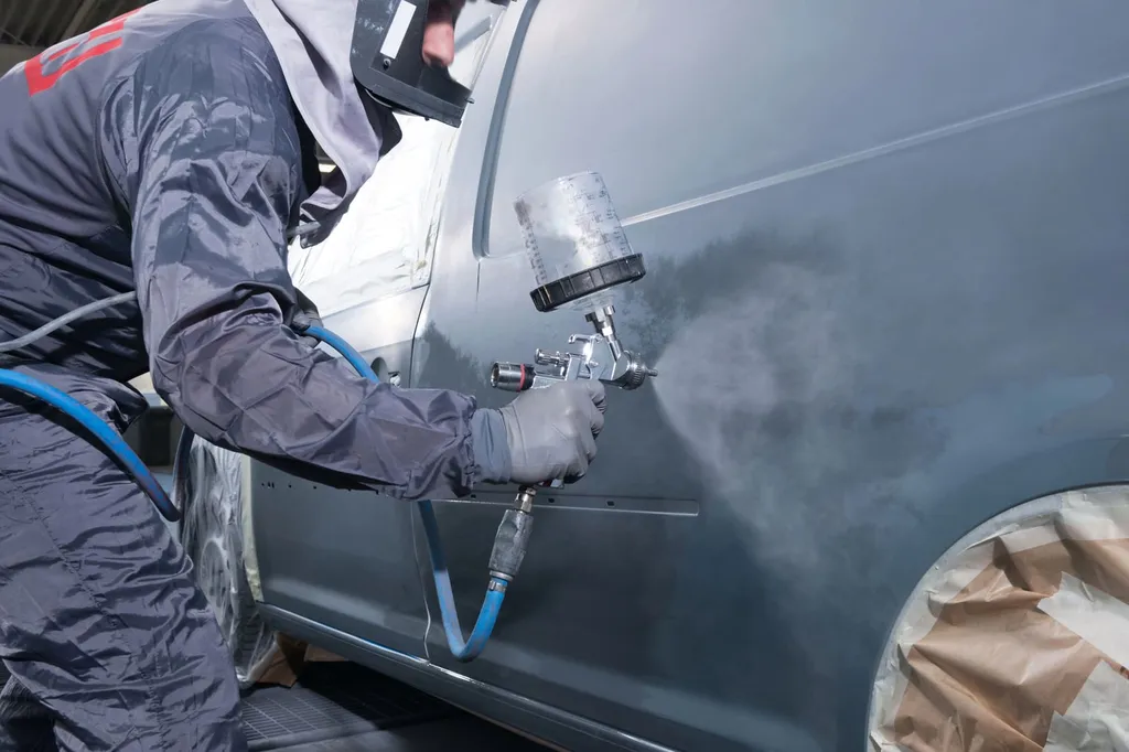 Peinture automobile sur portière en atelier de carrosserie pour corriger les défauts visibles et retrouver une surface uniforme.