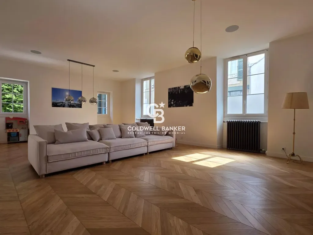 Vaste salon de réception, parquet en chevrons et grande luminosité